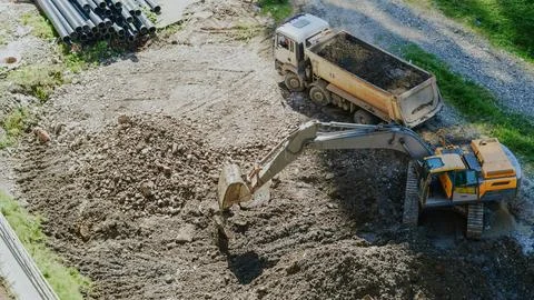 High angle view of an excavator loading dirt into a dump truck at a work site Stock Photos