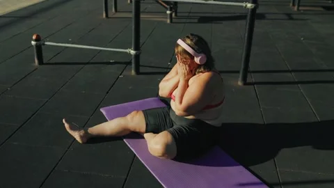 High angle view of an exhausted obese woman resting on a fitness mat. Stock Footage 344249777
