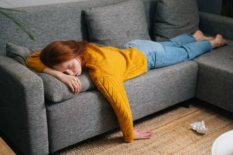 High-angle view of exhausted pretty woman sleeping on cozy couch in living room Stock Photos