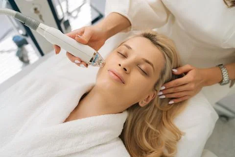 High-angle view face of serene female client lying with closed eyes and getting Stock Photos