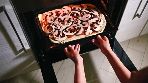 High angle view of female chef housewife placing pizza into oven.Video footage Video stock 156410736
