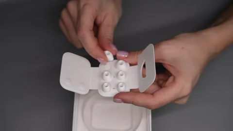 High-angle view of female hands showcasing various earbud sizes for wireless Stock Footage 293842481