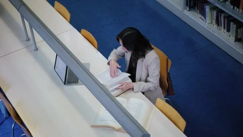 High Angle View of a Female Student Studying with Books in a Library Video stock 336041637