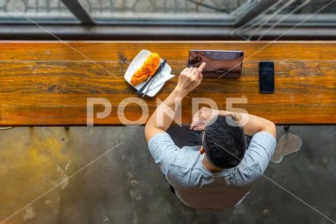 High angle view of freelancer using tablet and having breakfast Stock Photos