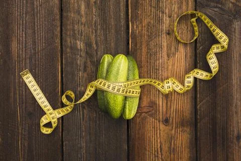 High angle view fresh cucumbers measuring tape wooden background Resolution and Stock Photos