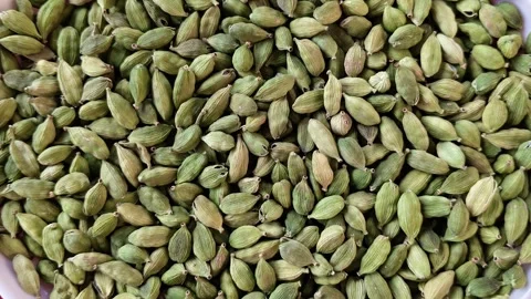 High angle view of fresh green cardamom pods in a white bowl on a red background Stock-Footage 326988554