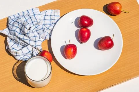 High angle view of fresh mini apple and a glass of milk on wooden cutting b.. Stockfoto's
