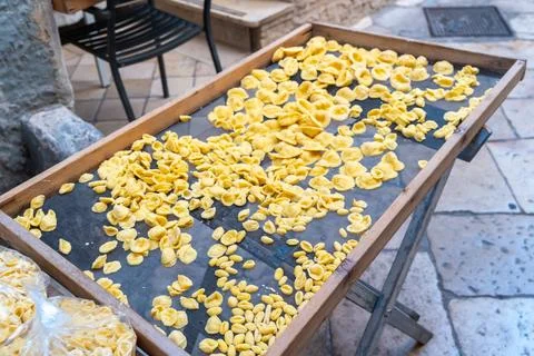 High angle view of fresh orecchiette pasta spread thinly on a dark mesh drying Stock Photos