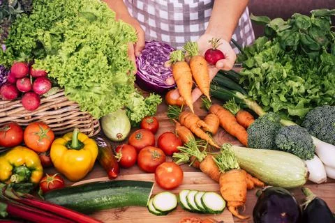 High angle view of fresh vegetables on kitchen counter while chef in apron re Stock Photos