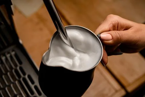 High angle view of fresh whipped foam of cream in jug in woman's hand Foto stock
