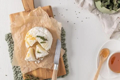 High angle view of fresh white cheese with golden honey and thyme on a wood.. 스톡 사진