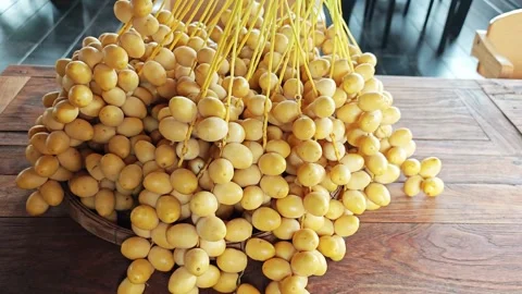 High Angle View of Fresh Yellow Date Palm Cluster on Wooden. Table Stock Footage 340488387