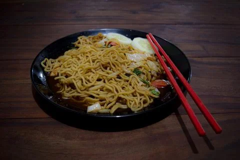 High angle view of fried noodle with sausage and vegetables on the wooden tab Foto stock