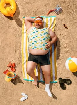 High angle view of funny overweight tourist resting on the beach Stock Photos