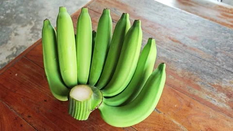 High angle view of green unripe banana bunch on wooden table. Stock Footage 340335329