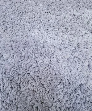 High angle view of a grey shaggy carpet with dense synthetic fibers in a si.. Stock Photos