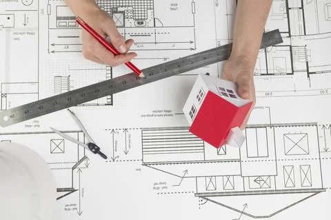 High angle view hand holding small house model pencil blueprint Stock Photos