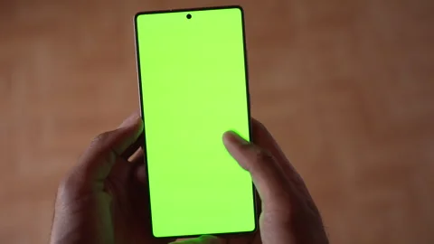 High Angle View of Hand Scrolling Smartphone Green Screen Mockup Chroma Key. Stock Footage 339087805