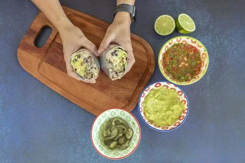 High angle view of hands holding mexican burrito ready to eat Stock Photos