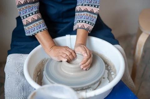 High Angle View Hands Opening Wet Clay Center on Potter Wheel in workshop s.. Stock Photos