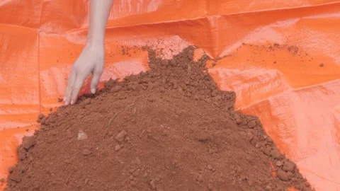 High angle view of hands removing red construction sand. Stock Footage 241841425