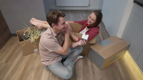 High angle view happy man with toy house sitting at parcels with joyful woman in Stockbeeldmateriaal 167561343