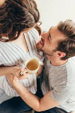 High angle view of happy young couple in love hugging while drinking coffee a Stock Photos