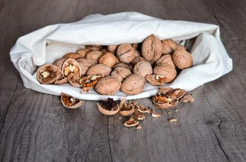 High angle view  of a hemp bag filled with whole and cracked walnuts  on  tab Stock Photos