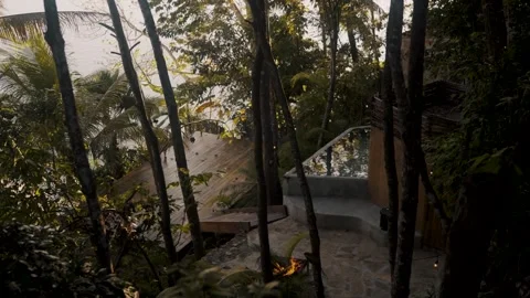 High angle view of a hidden yoga deck and plunge pool in a lush jungle by a lake Stock Footage 336477333