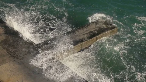 High angle view of high waves hitting the city beach shore. Stock Footage 79549069