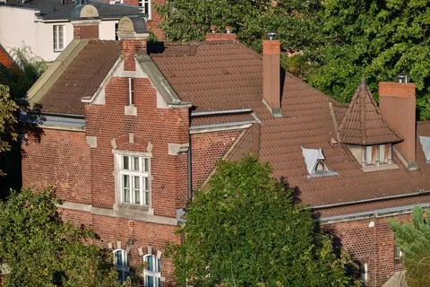 High angle view of a historic red brick building roof with gables and chimney Fotos de archivo