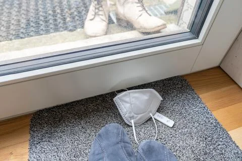 High angle view of house slippers and boots of person behind the window. Foto stock