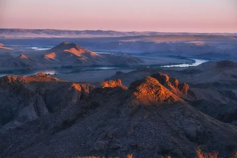 High-angle view of the Ili River winding through rocky canyon and desert moun 库存照片
