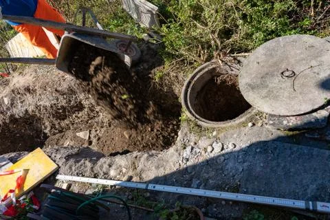 High angle view of laborer, dumping a wheelbarrow of soil. Foto stock