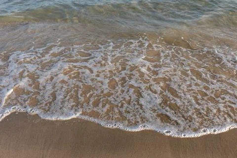 High Angle View of Laced Sea Foam Patterns on Sandy Beach Shoreline. Stock Photos