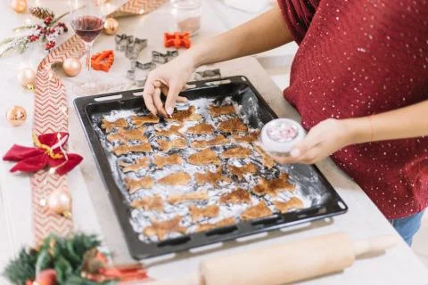 High angle view of a lady's hands decorating gingerbread cuttings for Christmas Foto stock
