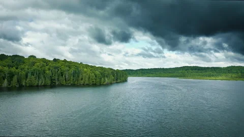 High Angle view of a lake and forest under storm clouds Stock Footage 202634161
