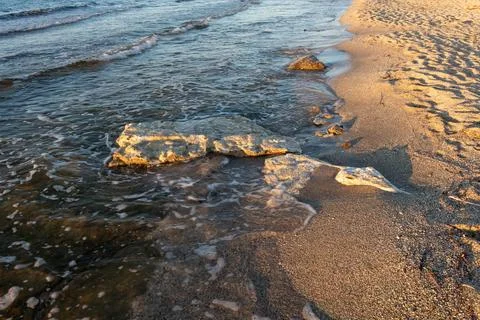 High angle view of large stone on sandy beach shore with sea waves Fotos Stock