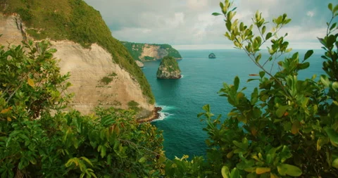 High angle view of limestone cliffs and rock formations in deep blue sea at Nusa Stock Footage 341294930