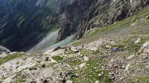High angle view of lone hiker standing on rocky edge of deep mountain gorge 库存影片 334326518