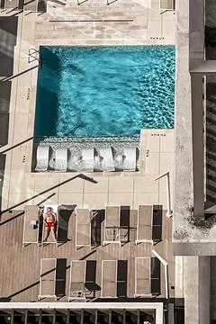 High Angle View Of Lone Man Laying Out By Pool Stock Photos