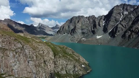 High angle view of lone tent above turquoise alpine lake, solitude adventure Видео 334326511