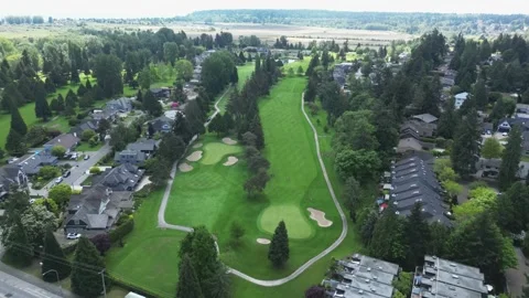 High-angle view of long green fairway and putting greens weaving through Stock Footage 337713372