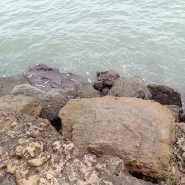 High angle view looking down at assorted coastal boulders sea waves Stock Photos