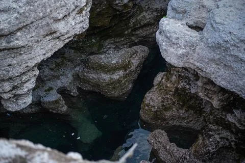 High-angle view looking down into a narrow, rugged stone crevice Stock Photos
