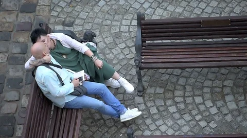 High angle view Lviv, Ukraine romantic couple sitting bench sound Stock Footage 97683916