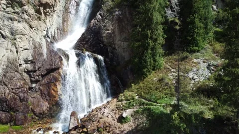 High angle view of majestic waterfall cascading down rocky cliff in pine forest 库存影片 334625127