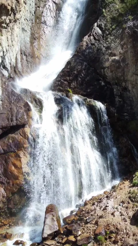 High angle view of majestic waterfall cascading down rocky cliff in pine forest Stock Footage 336691717