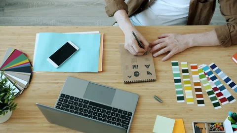 High angle view of male hands designer sketching logo symbols and typing with Stock Footage 157537286