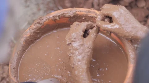 High angle view of male hands  mixing clay with water in bucket for construction Video stock 241841333